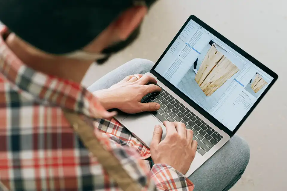 A craftsman checks a design on his laptop in the workshop