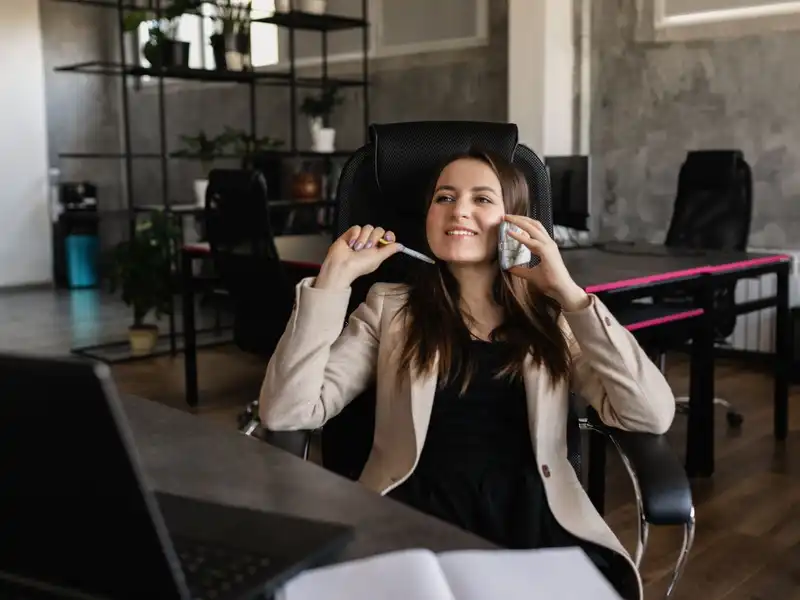 A woman smiling while she talks on the phone