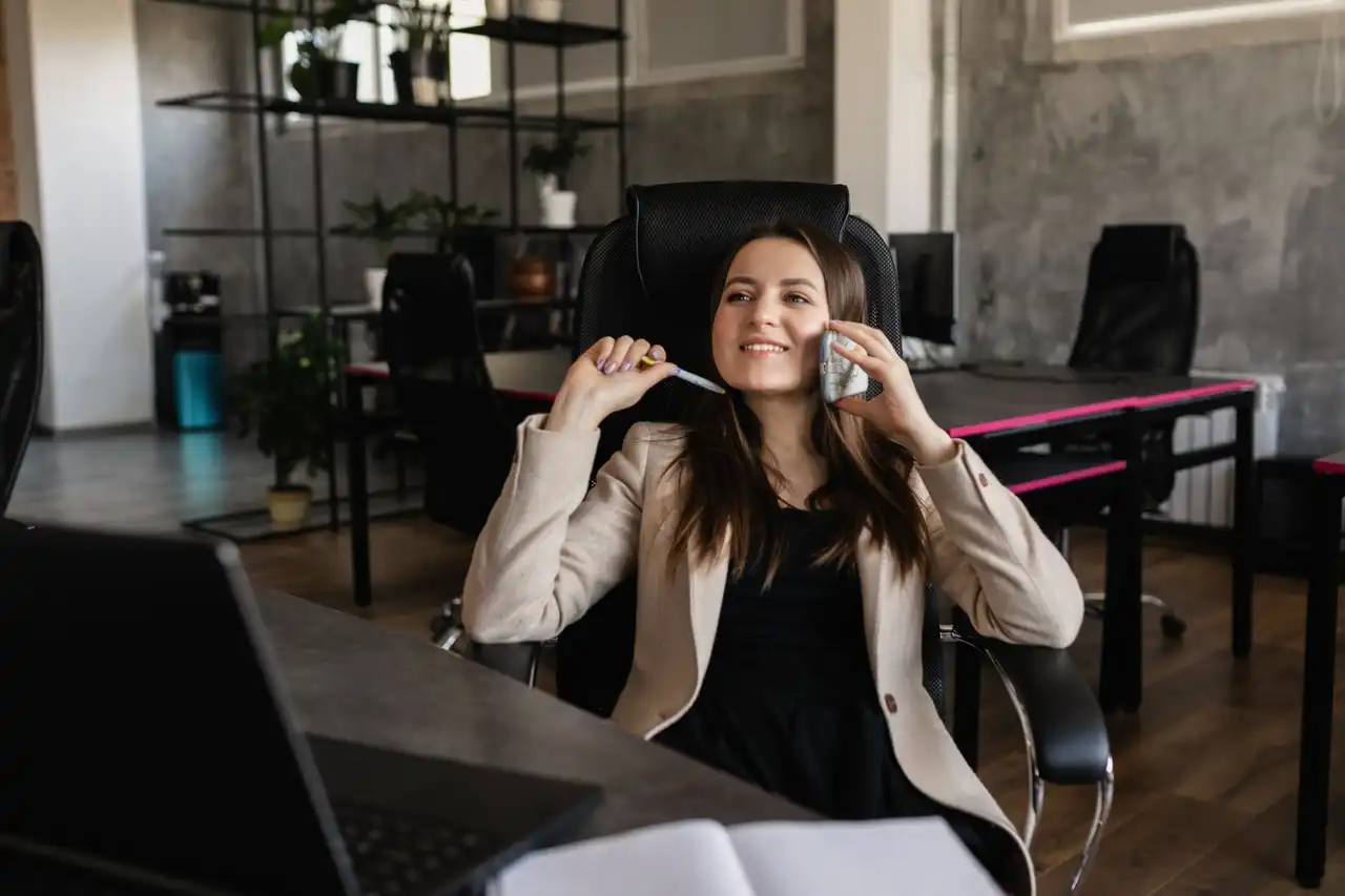 A woman smiling while she talks on the phone